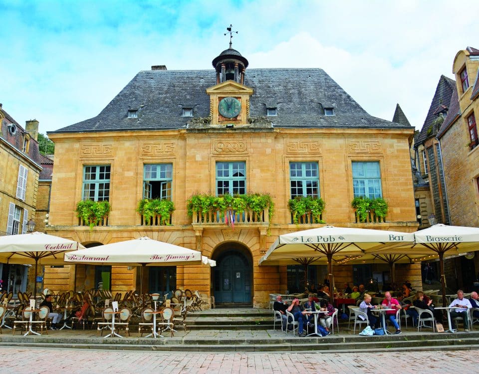 Altes Gebäude mit gelbem Mauerwerk und kleinem Glockenturm in Sarlat La Canéda